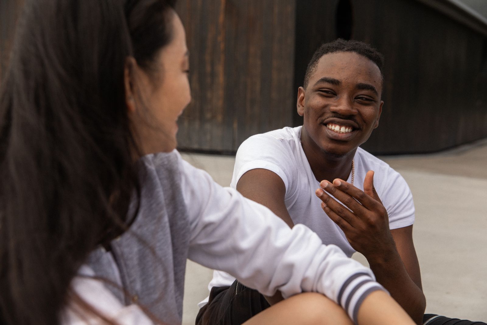 Two friends smiling and talking outdoors